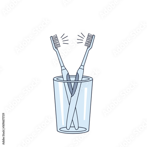 Two clean toothbrushes standing upright in a transparent glass container