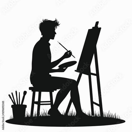 Male artist painting on an easel with brushes and palette Keywords: silhouette, man, painting