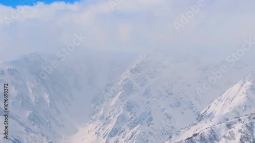 Telephoto panoramic video of the snowy peaks of the Hakuba mountain range in the Northern Alps (viewed from Tsugaike Mountain Resort, Hakuba, Nagano, Japan)