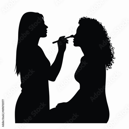 Silhouette of makeup artist applying makeup to a woman Keywords: silhouette, makeup, artist