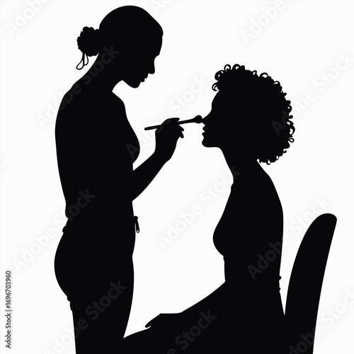 Silhouette of makeup artist applying makeup to client Keywords: silhouette, makeup artist
