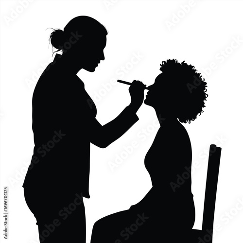 Silhouette of makeup artist applying makeup to client Keywords: silhouette, makeup artist