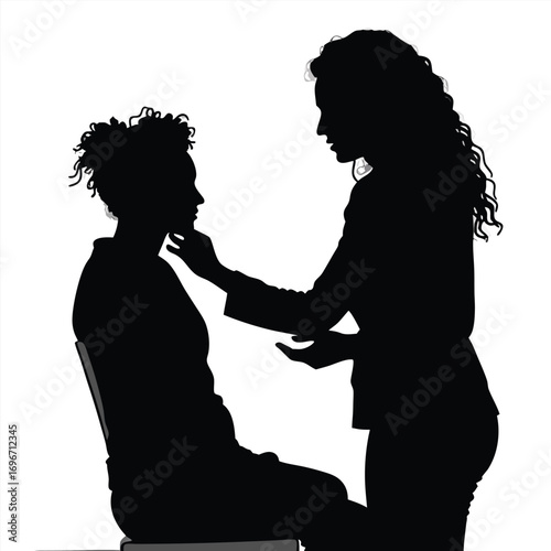 Silhouette of makeup artist touching client's face