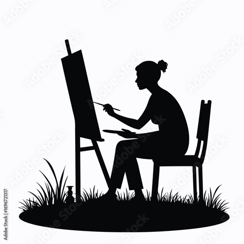 Woman artist painting on easel in silhouette canvas