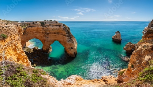 beautiful algarve coastline with natural arch and turquoise water
