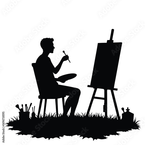 Silhouette of a man painting on an easel outdoors artist