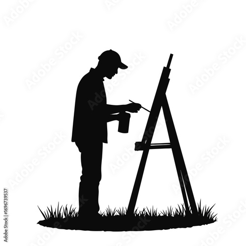 Silhouette of a man painting on an easel with a paint can