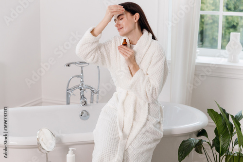 Young woman enjoying a skincare routine in a modern bathroom setting
