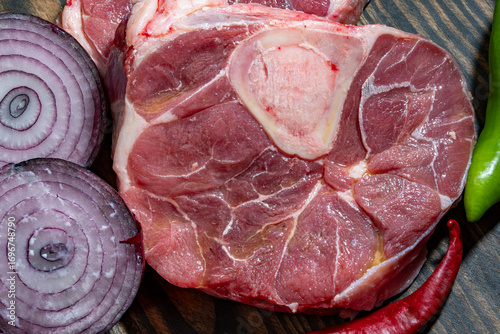 filete de osobuco crudo, pierna de res cortada en rodajas con cebolla morada, pimiento rojo y verde