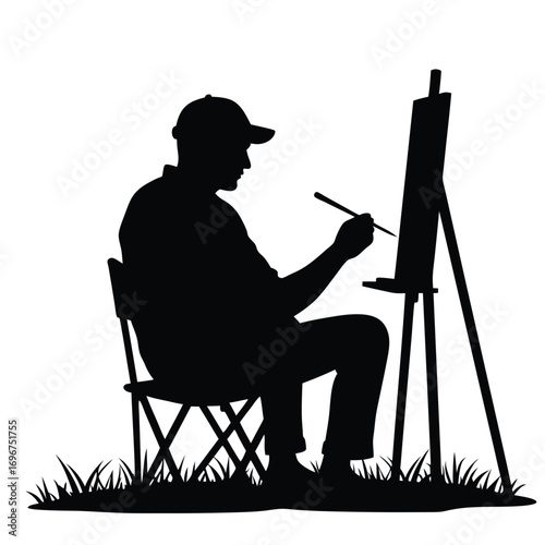 Silhouette of an artist painting on an easel in the grass