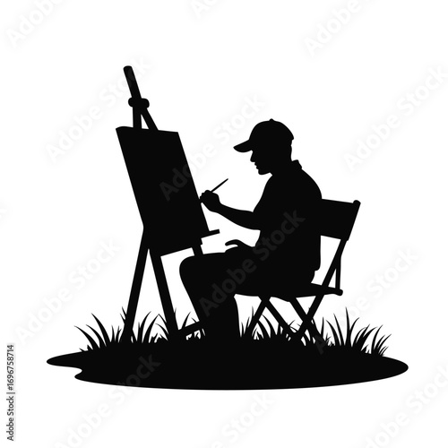 Silhouette of man painting on easel in grassy area