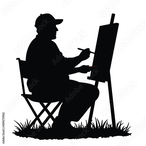 Silhouette of man painting on easel in grassy area