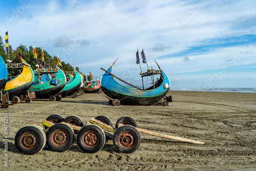 Colorful Fishing Boats on Sandy Beach with Cloudy Sky at Teknaf Sea Beach. Colorful Wooden Fishing Boat On a Cox's Bazar Sea Beach, Bangladesh With Blue Sky Background. 