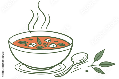 Bowl of hot soup with spoon and leaves