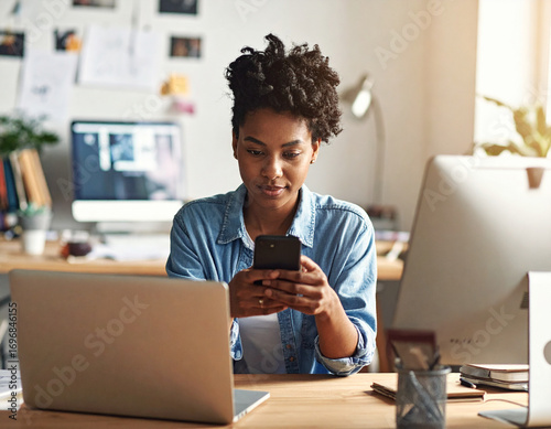 Young African American black woman working on laptop and mobile phone
