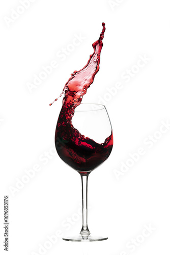 Vibrant red wine splashing from a bottle, pouring into a glass on a white background