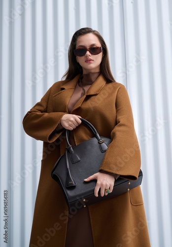 Fotografía Girl model in stylish clothes with bag posing in studio