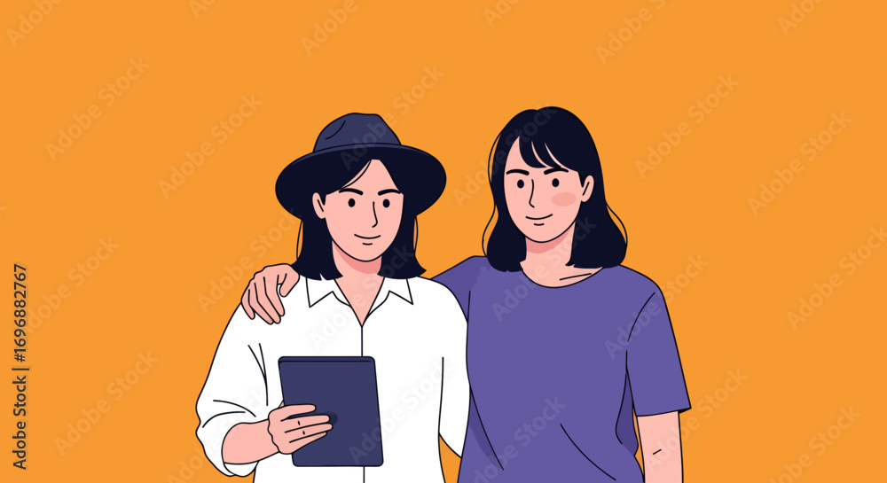 Fototapeta premium Two smiling women one in a hat holding a tablet arm around the other.