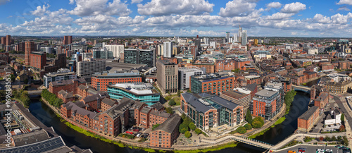 Aerial panorama of Leeds city centre featuring the River Aire, Leeds Dock, and urban skyline in Yorkshire, Northern England.