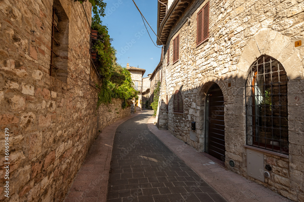 Naklejka premium Beautiful Tuscan historical street and place in the city of Assisi, Tuscany, Italy, Europe. Medieval atmosphere