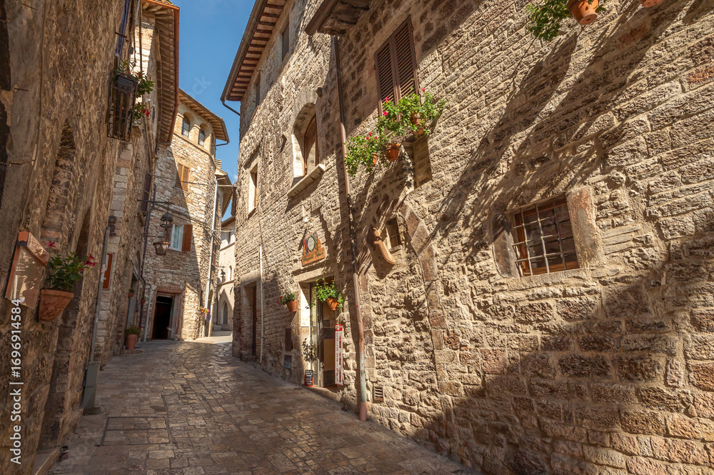 Naklejka premium Beautiful Tuscan historical street and place in the city of Assisi, Tuscany, Italy, Europe. Medieval atmosphere