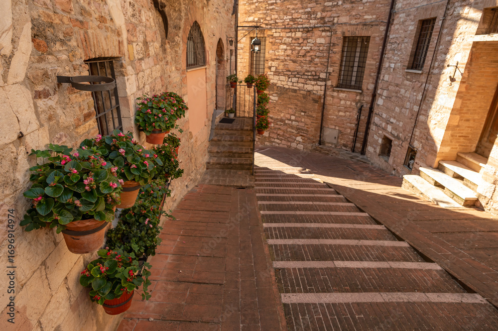 Naklejka premium Beautiful Tuscan historical street and place in the city of Assisi, Tuscany, Italy, Europe. Medieval atmosphere