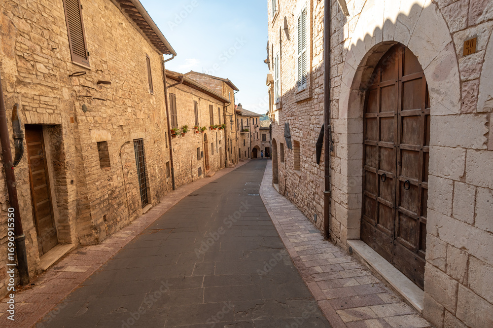 Naklejka premium Beautiful Tuscan historical street and place in the city of Assisi, Tuscany, Italy, Europe. Medieval atmosphere