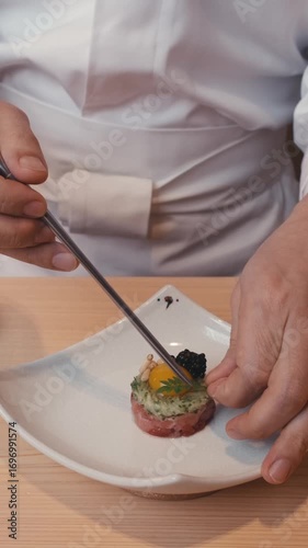 close up asian food preparation of traditional sushi rolls. presentation of dishes of Asian haute cuisine in Michelin-starred restaurant. chef hands create cuts decorates dish slow motion. Chef coat