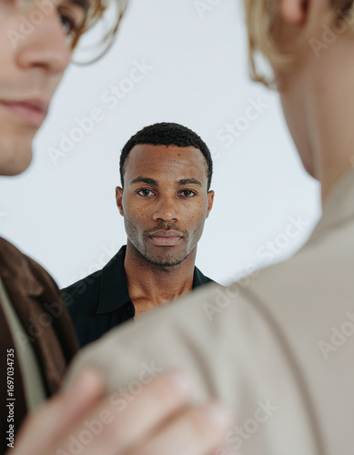 Focused Man Looking Through Two People in Minimal Studio Portrait