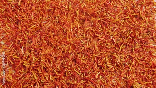 Dried crimson saffron on grey desk close-up macro. Orange red spice for food. Crocus sativus flower saffron
