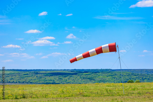 Foto Striped windsock on a sunny day in open field landscape
