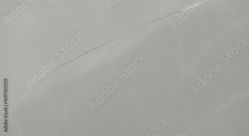 A close-up view of a light gray marble surface with subtle veining and a prominent crack running diagonally across the frame.