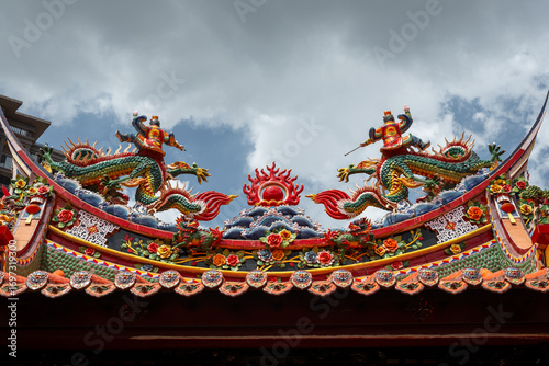 Intricate Dragon Sculptures on the Roof Ridge of a Traditional Chinese Temple Featuring the Mythical 'Two Dragons Playing with a Pearl' Motif