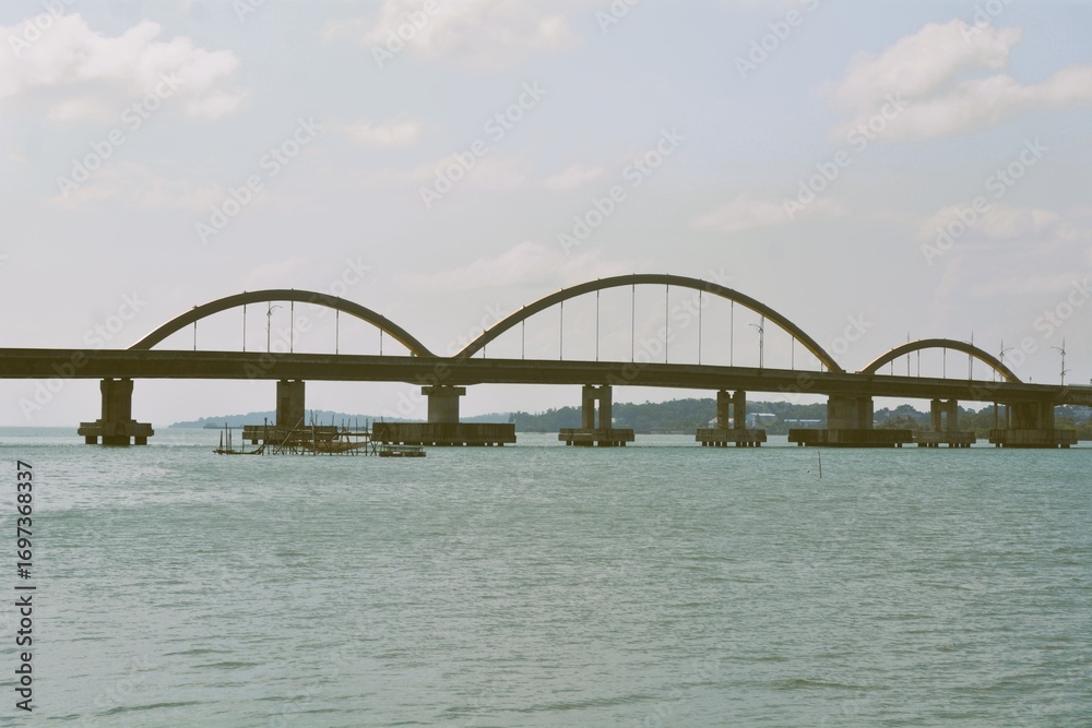 Fototapeta premium View from a bridge over the sea with tree arcs which connecting island and downtown area