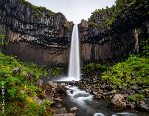 Majestic Svatifoss waterfall cascading over basalt columns in nature