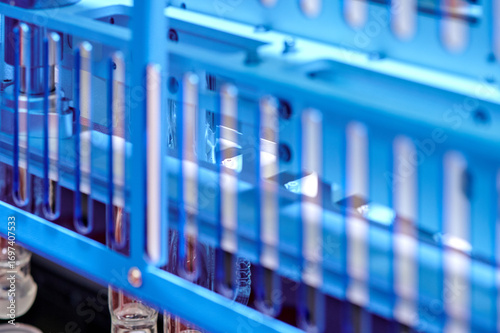 Modern Laboratory Equipment with Blue Racks Holding Scientific Test Tubes in Bright Illumination for Medical Research and Development