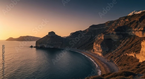 Golden sunset illuminates a coastal cove with rugged cliffs and calm water