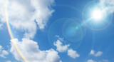 夏の晴天、青空に流れる積乱雲ふわふわの入道雲と輝く太陽のレンズフレア 夏・夏休み・行楽・バカンス・アウトドア・キャンプ・天気・台風一過・紫外線・日焼け