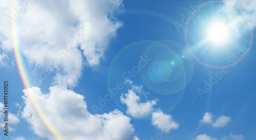 夏の晴天、青空に流れる積乱雲ふわふわの入道雲と輝く太陽のレンズフレア 夏・夏休み・行楽・バカンス・アウトドア・キャンプ・天気・台風一過・紫外線・日焼け