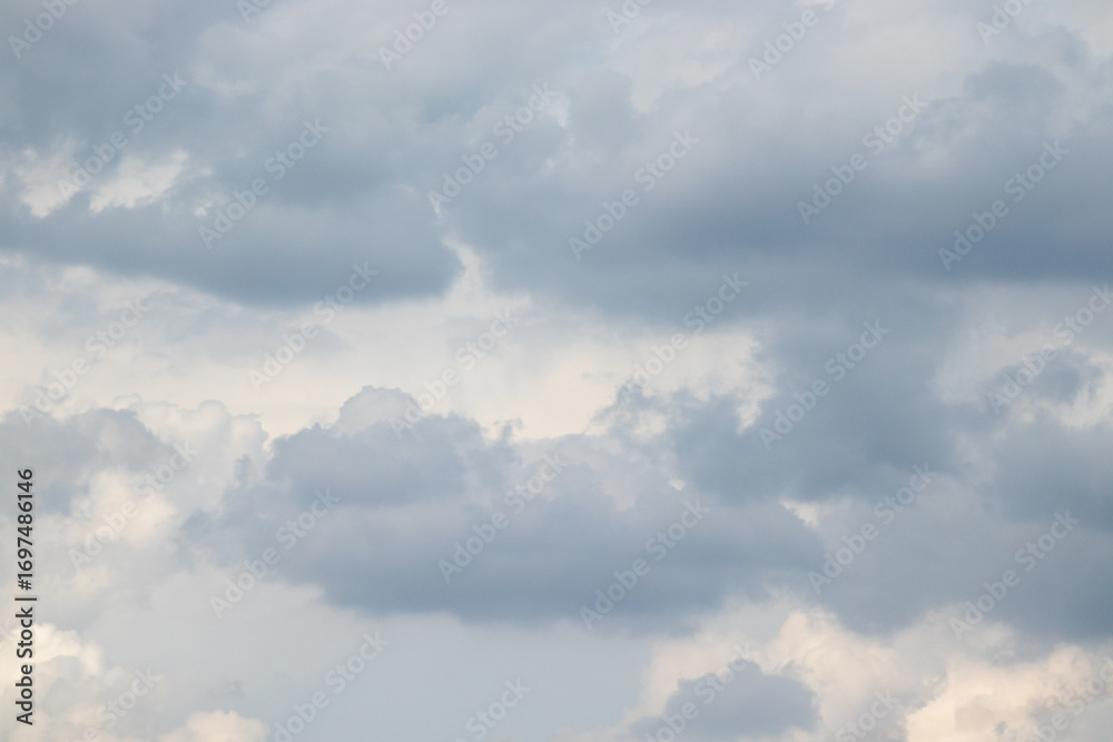 Fototapeta premium Overcast sky with thick gray clouds stretching across the horizon, creating a calm yet moody atmosphere above a distant landscape.