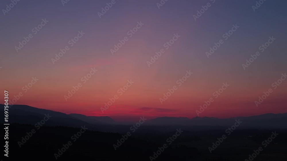 Vibrant Skies Over Silhouetted Mountain Range In Cowichan Valley on Vancouver Island, Canada. - aerial shot Vibrant Skies Over Silhouetted Mountain Range In Cowichan Valley on Vancouver Island, Canada. - aerial shot