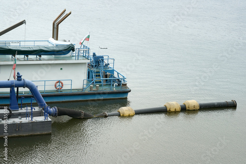 Fototapet Industrial dredging vessel on the Danube River in Bulgaria using a floating pipeline for sediment removal and waterway maintenance