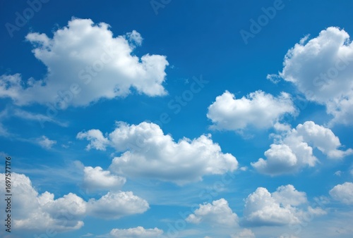 A bright, expansive, blue sky is dotted with puffy, white clouds creating a serene, open, and airy atmosphere during a sunny day