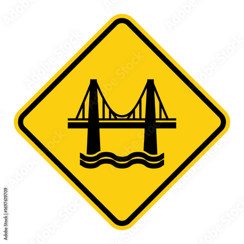 Yellow diamond-shaped road sign with a black silhouette of a suspension bridge over water, indicating a bridge ahead warning.