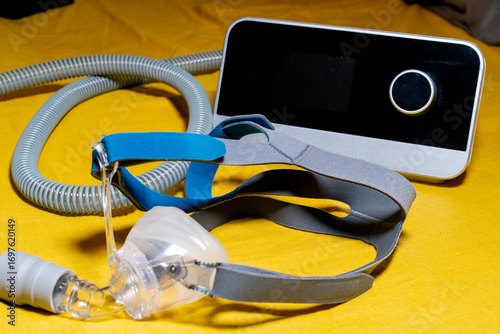 Tube and mask of the Obstructive Sleep Apnea CPAP Machine on a yellow surface.
