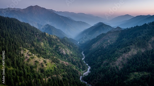 Breathtaking aerial view of a river winding through lush green mountains at dusk.