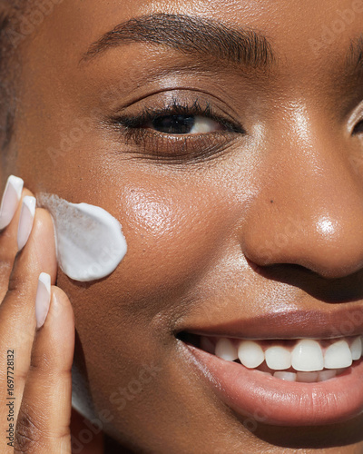 Morning Skin care beauty portrait. Cream smear. Hydration and oil balance. Nourishing and moisturising. African American young woman with afro braids hairstyle is applying cosmetic product on her face