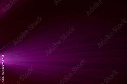 intense purple spotlight beam emanating from a central point, creating a tunnel-like effect. The background is pitch black