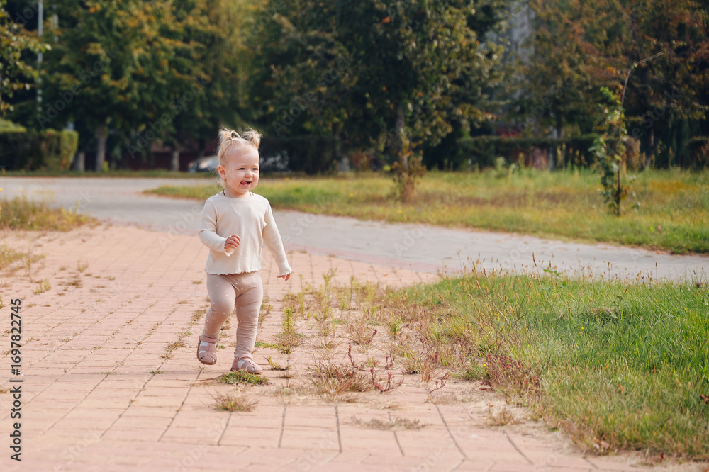 Fototapeta premium Little girl walking outdoors, cheerful child enjoying happy summer childhood in fresh air 