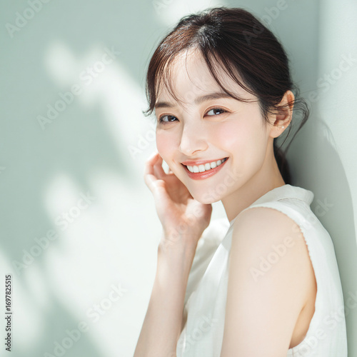 笑顔できらめく綺麗な肌と白い歯を見せる日本人女性美人モデルの接写写真。オーラルケア、スキンケア、コスメ広告用。